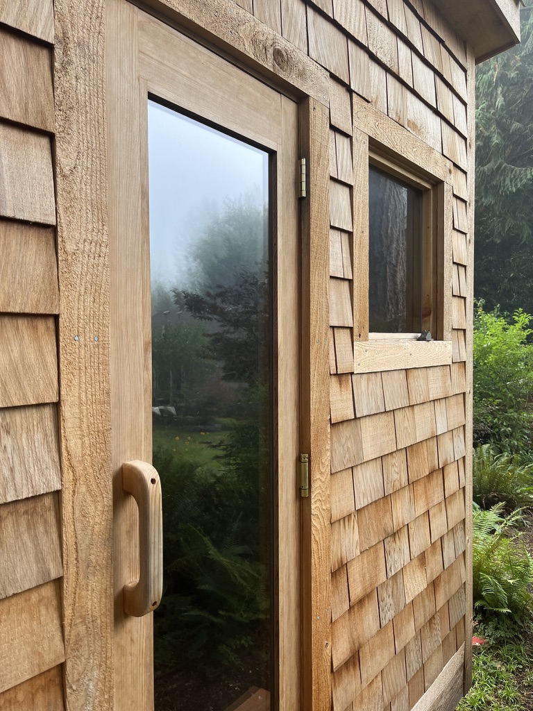 Cedar sauna door and shingle exterior in the garden